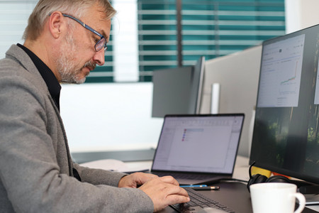 Person sitzt arbeitend vor ihrem Laptop.